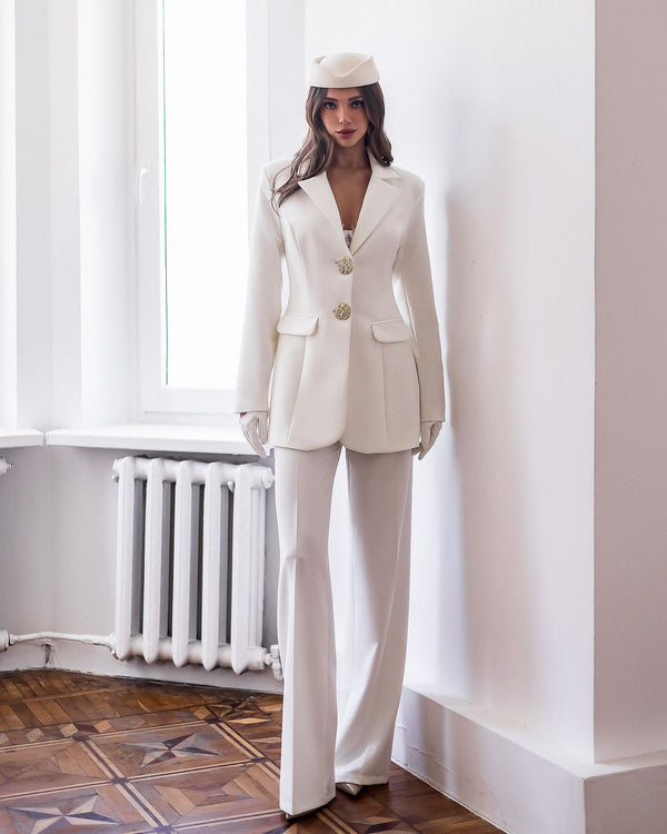 Almira Suit in white, full-length seated pose
