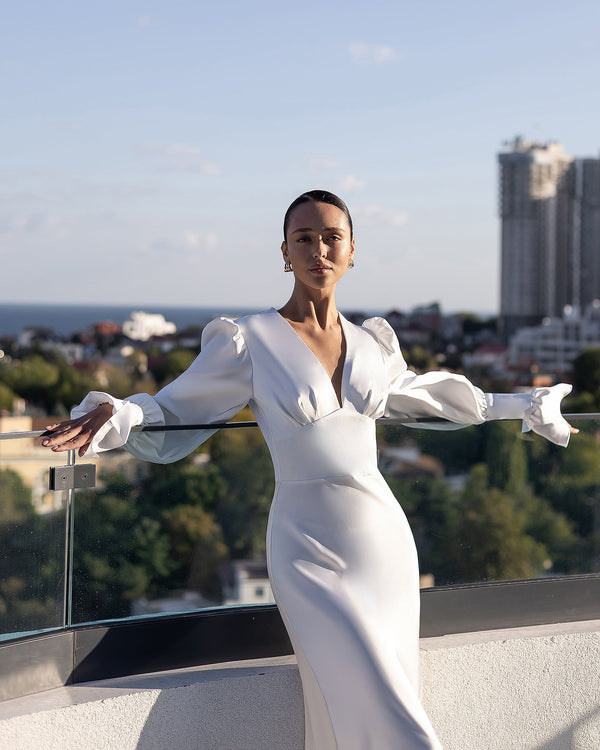 Elviana Dress in white, seated outdoor pose