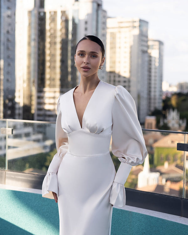 Elviana Dress in cream, cityscape standing pose, evening