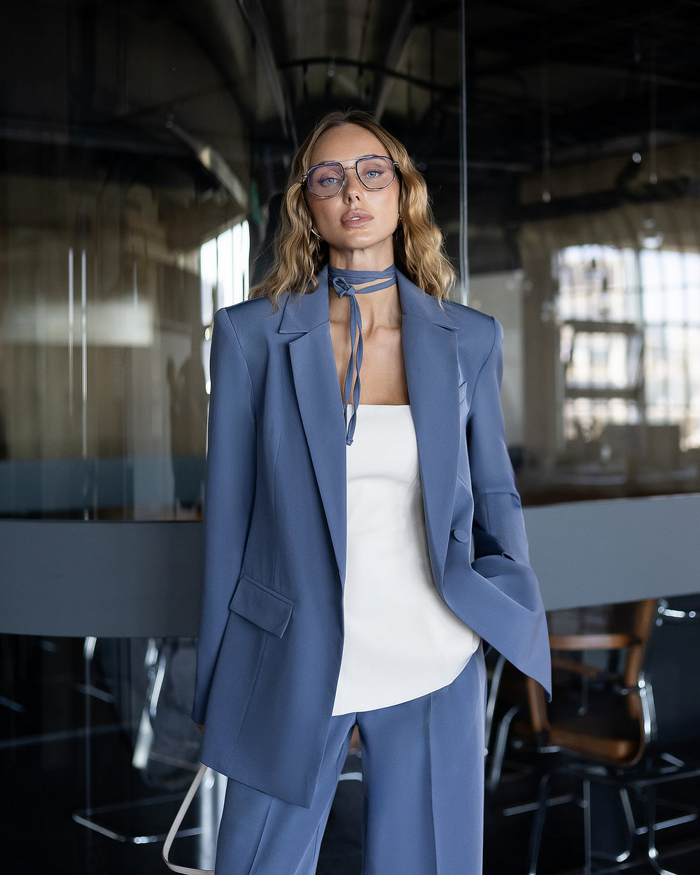 Person wearing a blue suit and white top in an office setting