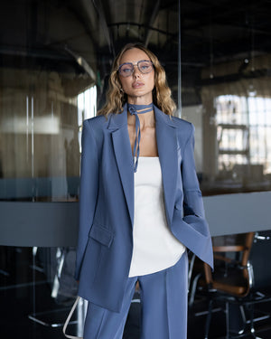 Person wearing a blue suit and white top in an office setting