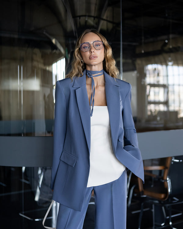 Person wearing a blue suit and white top in an office setting