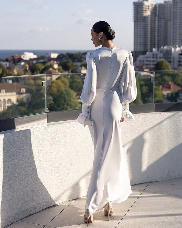 Elviana Dress in white, back view, architectural setting