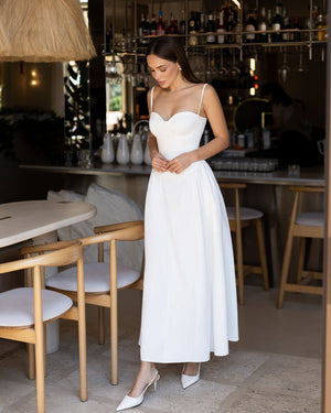 Odette Midi Dress in white, interior full-length pose on terrace